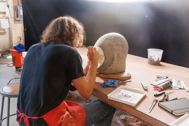 A student works on details of a ceramic head.