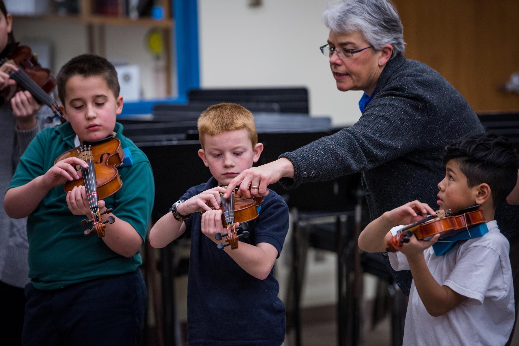 Teacher with a students violins