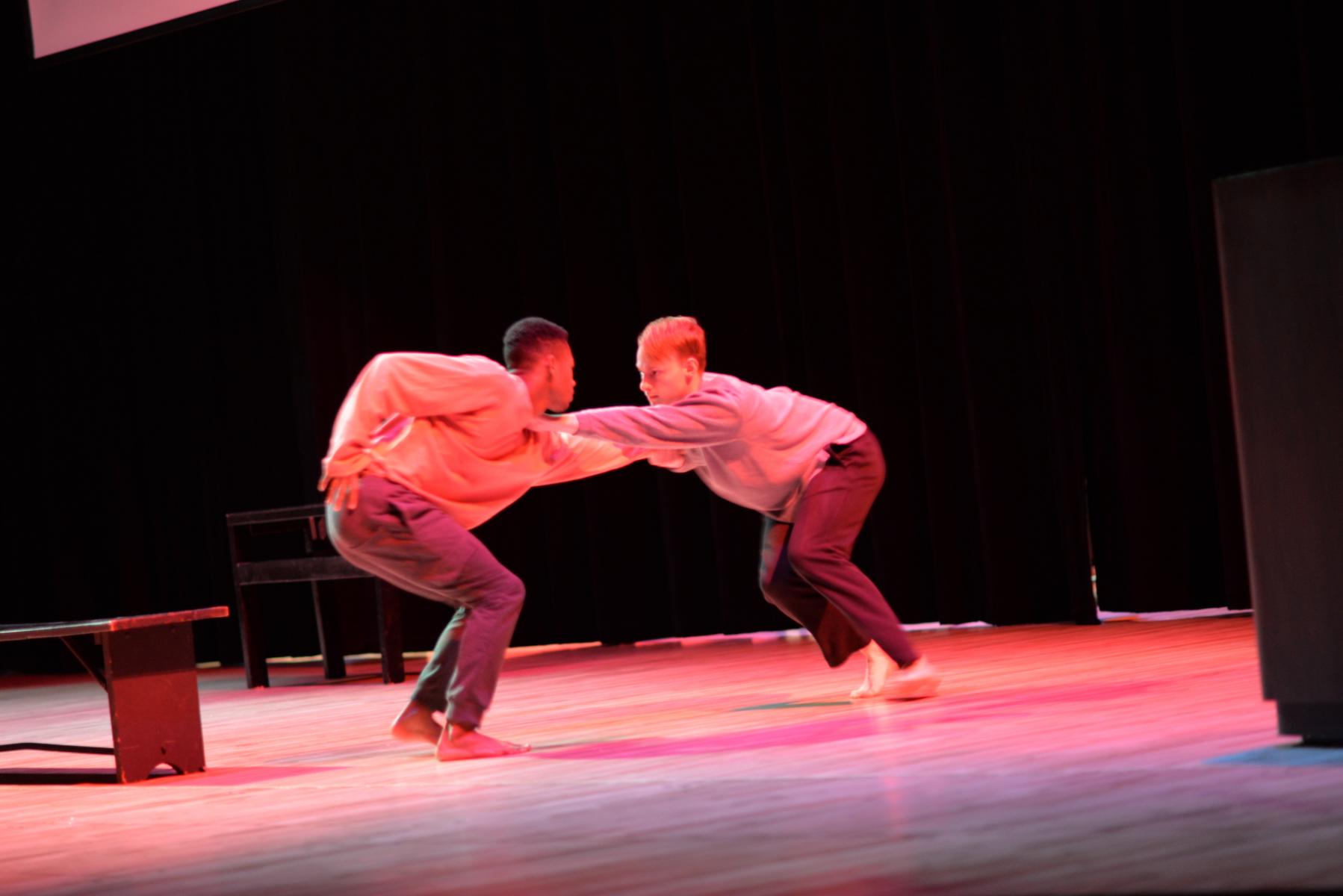 Dance performance image, Two men locked arms facing each other