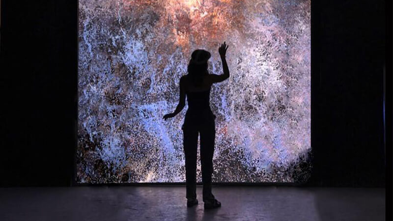 Student standing in front of backlit screen