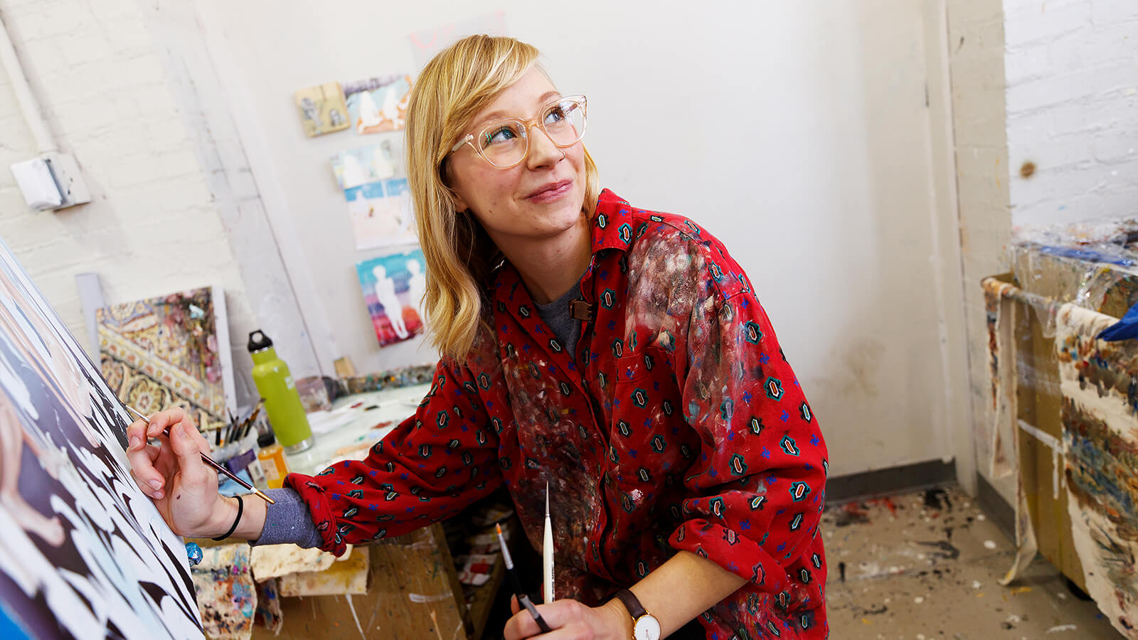 Student in studio working on painting