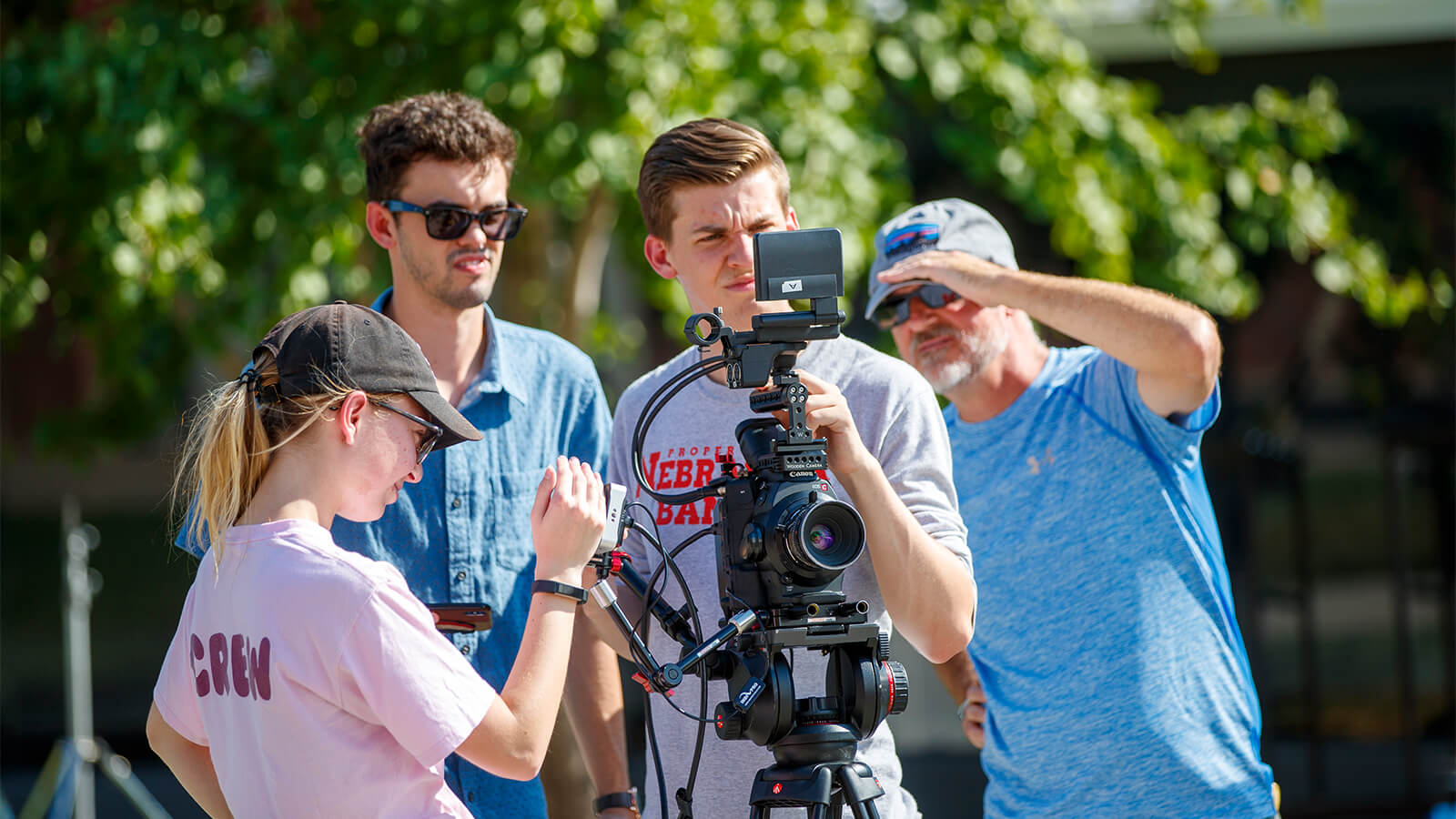 Students holding camera while working on project