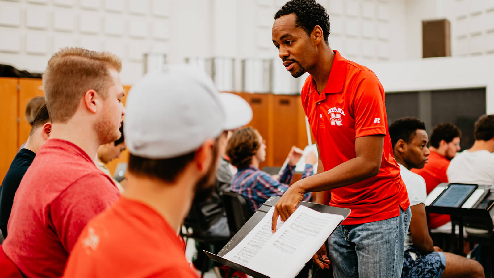 Professor points to sheet music while engaging with student