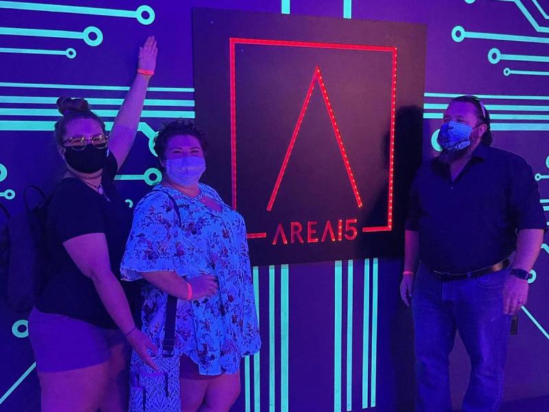 Two Carson School students and an instructor posing in front of the Area15 entryway signage.