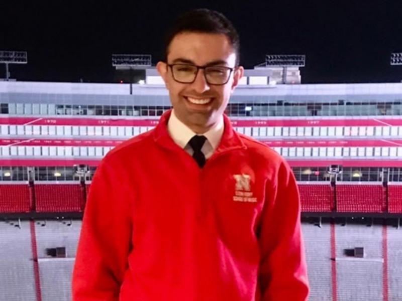 A portrait of Zachary Cheek with the lit stadium in the background at dark.