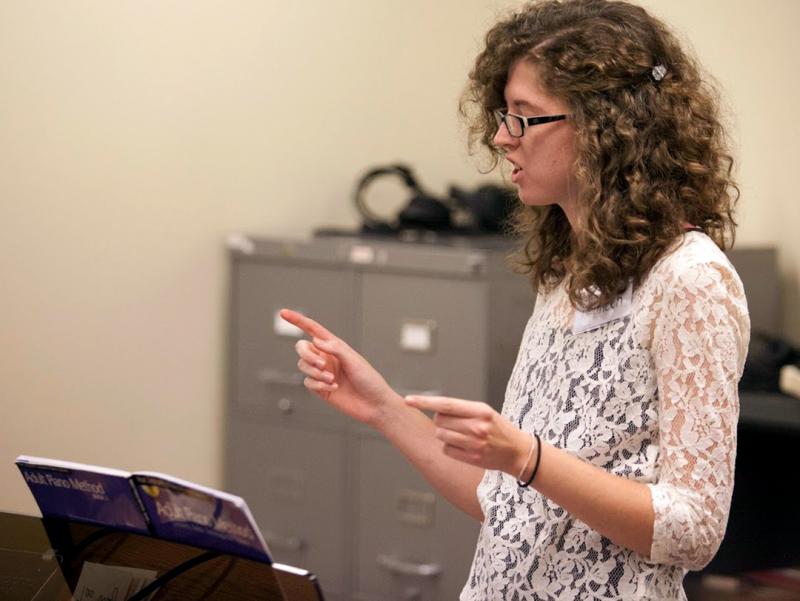 A Glenn Korff School of music student giving instruction to community members taking lessons as part of the Community Piano Experience.