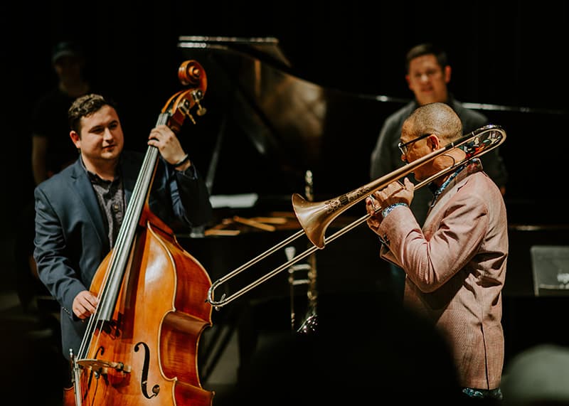 A band plays on stage with a guest artist.