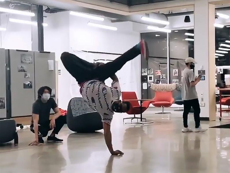 An Orchesis member street dancing in the middle of a large, open room while other Nebraska students attending the Street Dance Open Session observe.