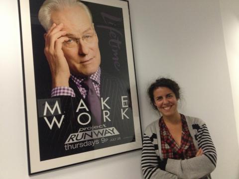 Josie Azzam portrait at work next to Project Runway poster