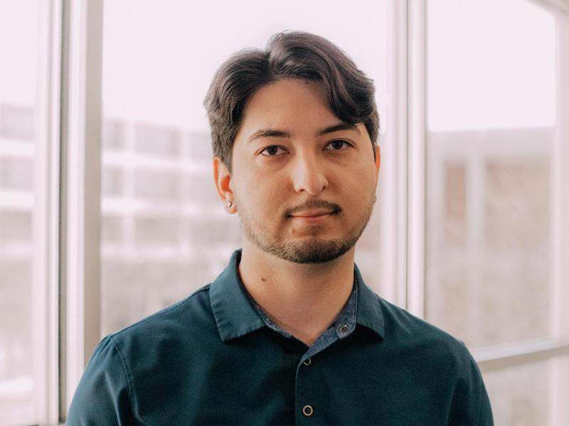 Portrait of Agustin Mendez in front of windows.