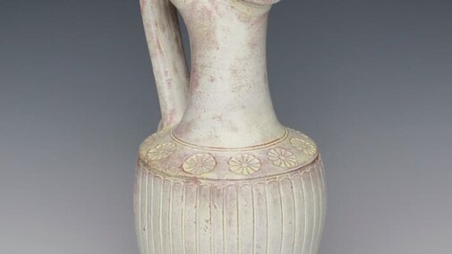 a tall pitcher vessel with spotty white glazing