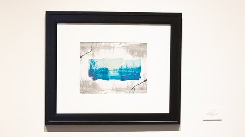 a print with blue in a black frame
