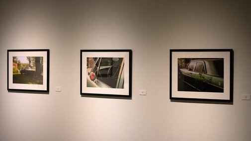 three framed images of a car hang on the gallery wall.