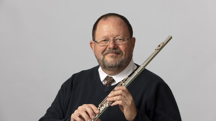 Headshot of John Bailey holding his flute.