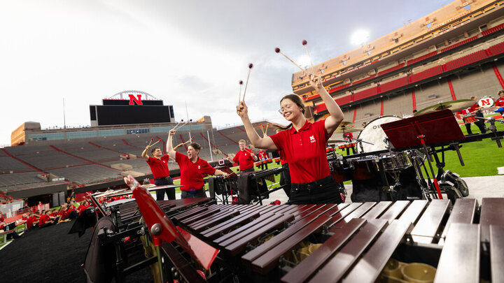 Members of the pit raise their mallets amid a percussion performance during the Cornhusker Marching Band’s annual exhibition concert Aug. 22 at Memorial Stadium. The band will make its regular-season debut Sept. 6 at the stadium with pregame and halftime performances during Nebraska’s football home opener against Akron.