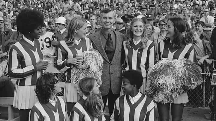 Late-night television icon Johnny Carson, a 1949 Husker graduate, poses with Nebraska cheerleaders in Memorial Stadium during the 1971 football game with Kansas. (University of Nebraska–Lincoln Archives and Special Collections)
