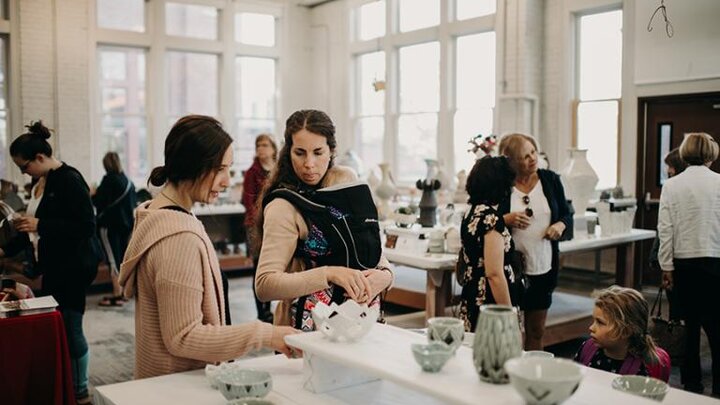 People look at ceramics for sale by Clay Club.