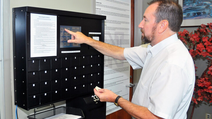 Patrick Barrett, director of transportation services, demonstrates the new automated auto rental system available on City and East campuses. Barrett was honored by the National Association of College and University Business Officers for the implementation of the Keyosk system.