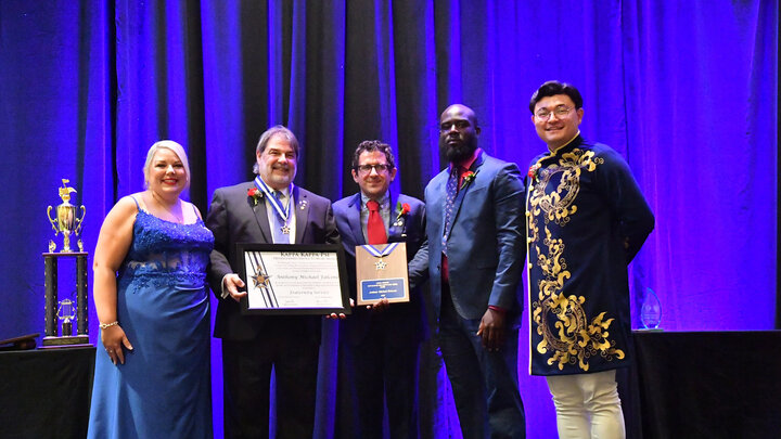 Tony Falcone (second from left) receives the Kappa Kappa Psi Distinguished Service to Music Medal in July. It is the highest award presented by the national honorary band fraternity. Courtesy photo.