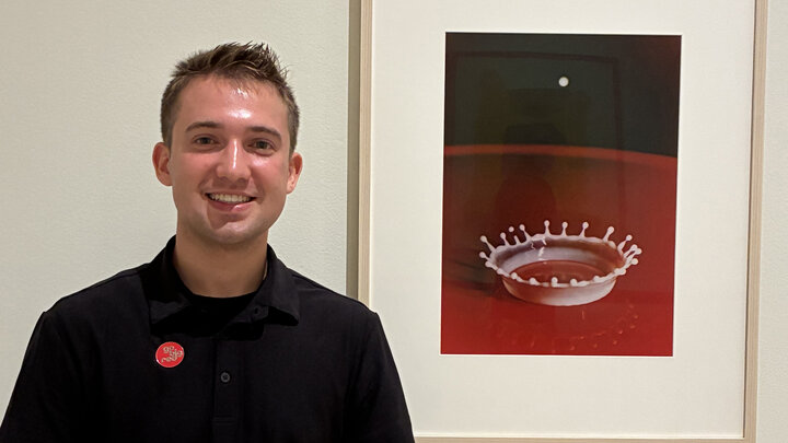Tanner Maas, a drum major with the Cornhusker Marching Band, stands by the work he selected, Harold Edgerton’s “Milk Drop Coronet,” for the exhibition “Go Big Red” on display at Sheldon Museum of Art through Dec. 31.