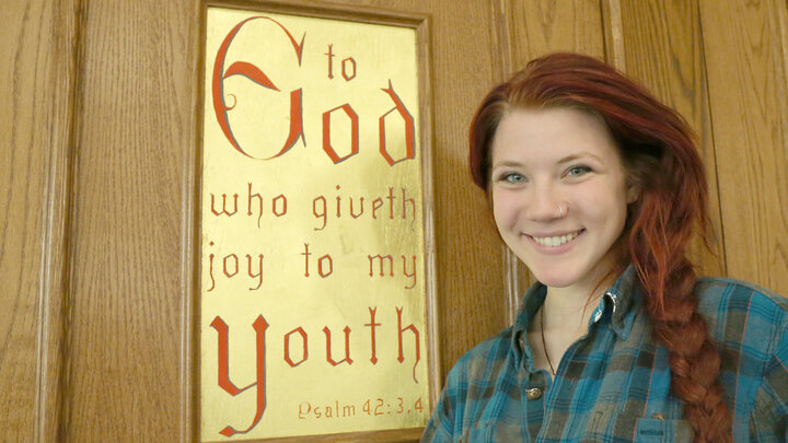 Anneleise Feldner, a sophomore art major, stands next to a Newman Center door panel she helped Bill Adair adorn with gold leaf and paint.