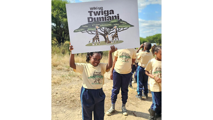 Children in Tanzania wear the t-shirts and display a poster with the graphic designed by UNL graphic design students Abigail Bubak, Lindsey Johnson and Johna Moural for World Giraffe Week for Mongabay Kids. Courtesy photo.