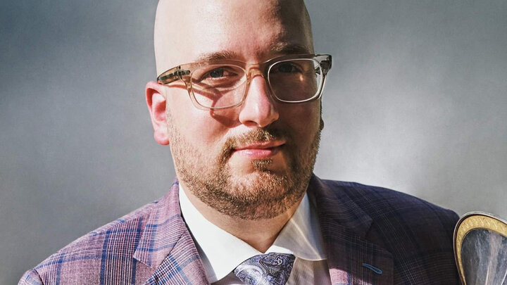Steven Cohen headshot. He is holding his French horn.