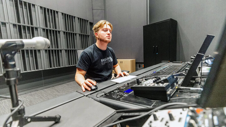 James Rasser working at a sound mixing console in the professional recording studio in Westbrook Music Building.