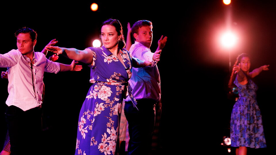 Dancers perform on stage.