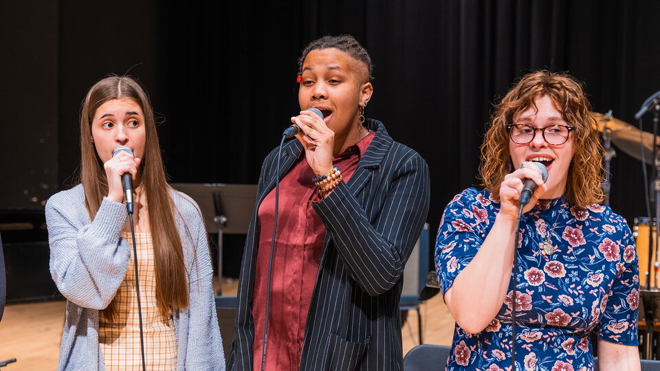 Jazz singers perform on stage.