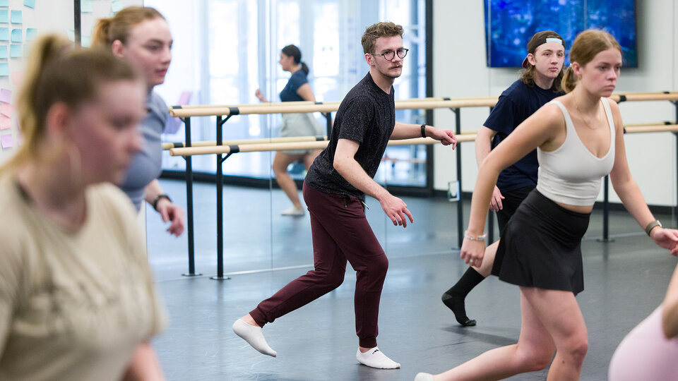 Dancers practice a routine in the studio.