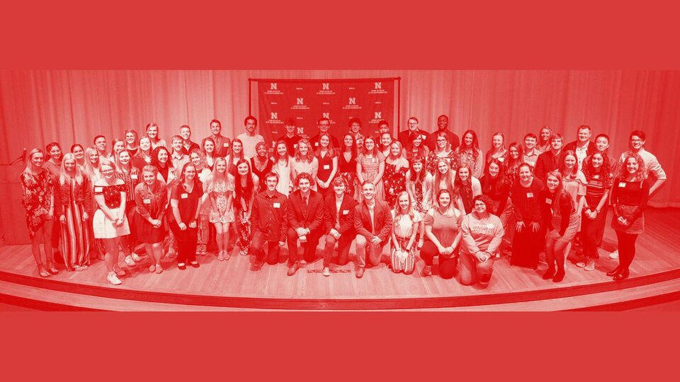 A very large group of young people posing for a photo on a stage.