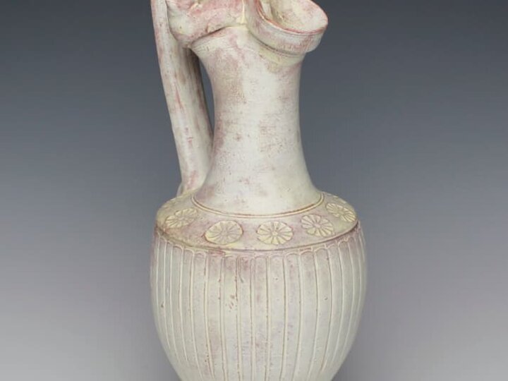 a tall pitcher vessel with spotty white glazing