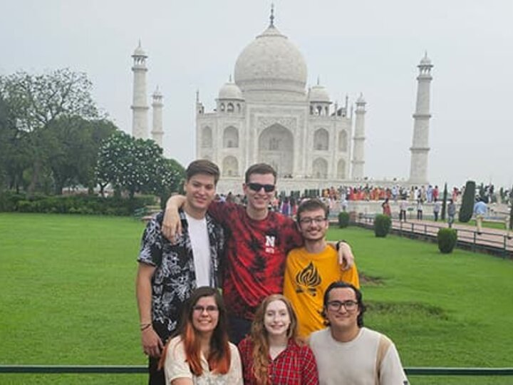 A group of six students poses in front of the Taj Mahal.