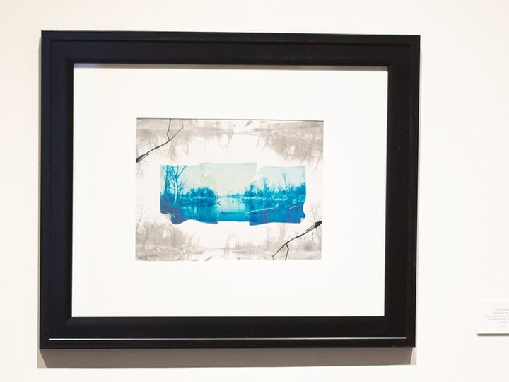 a print with blue in a black frame