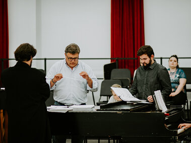 People stand around focused on conducting