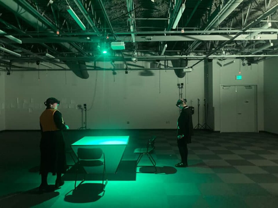 An open lab room with a single table lit by an eerie green light.