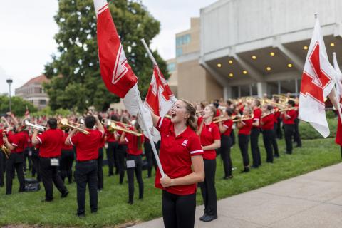 Color guard member Haley Petri chants “Go Big Red” during the Cornhusker Marching Band’s warm-up concert north of Kimball Recital Hall on Aug. 20. The band then marched to Memorial Stadium for its annual exhibition before it was canceled due to lightning. The band will make its 2021 debut Sept. 4 at the stadium with pregame and halftime performances at Nebraska's football home opener against Fordham. Photo by Craig Chandler/University Communication.