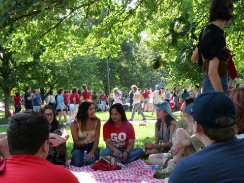 Sanskriti Duwadi (center, in red shirt), a freshman acting major from Nepal and a member of the first cohort of the Global Arts Academy, visits with students at the Student Welcome Back Picnic on Aug. 22. Photo by Muskan Yadav.