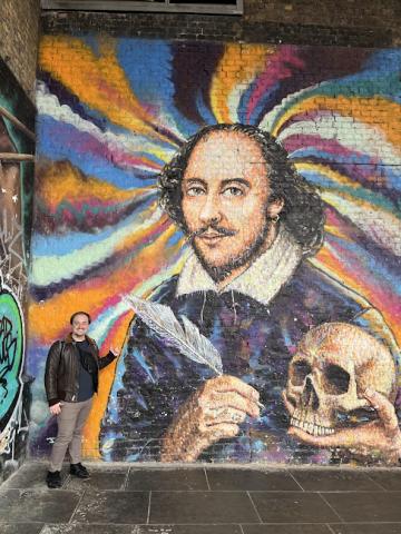 Jackson Wells stands by a mural of William Shakespeare. Courtesy photo.