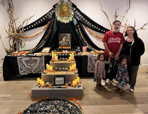 Angelica Tapia (right) with Elvira Hernandez’s nephew, Victor Hernández Chávez, and his family next to the altar honoring Elvira Hernandez at the Smithsonian’s National Museum of American Latino Día de los Muertos installation. Courtesy photo.