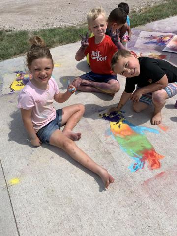 Students from the Alliance Recreation Center create spray chalk animals as part of the Stay Wild community arts project, led by Associate Professor of Art Sandra Williams. Courtesy photo.