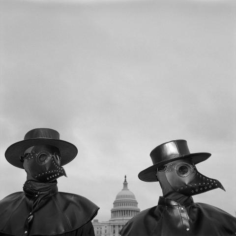 Two activists wear beaked masks like doctors wore in the 17th century during times of plague, seeking to draw the attention of spectators around Capitol Hill. Their message: Refusing to be vaccinated will prolong the COVID-19 pandemic. On the same day, two House subcommittees held a joint hearing titled “Disinformation Nation: Social Media’s Role in Promoting Extremism and Misinformation.” © Louie Palu.