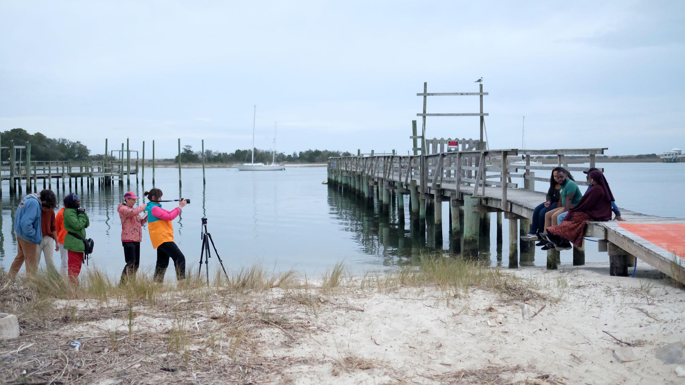 Emerging Media Arts students filming on set along a shoreline and dock in Seabreeze.