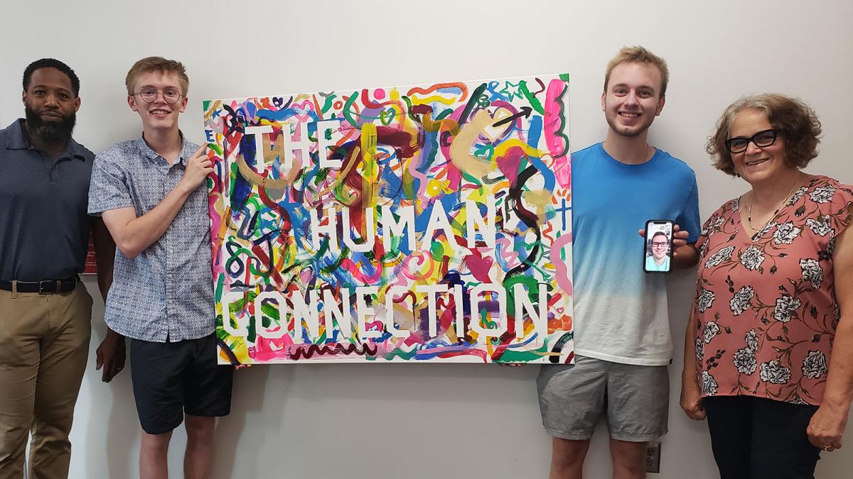 Nebraska students holding up the product of 'The Human Connection' collaborative painting project.
