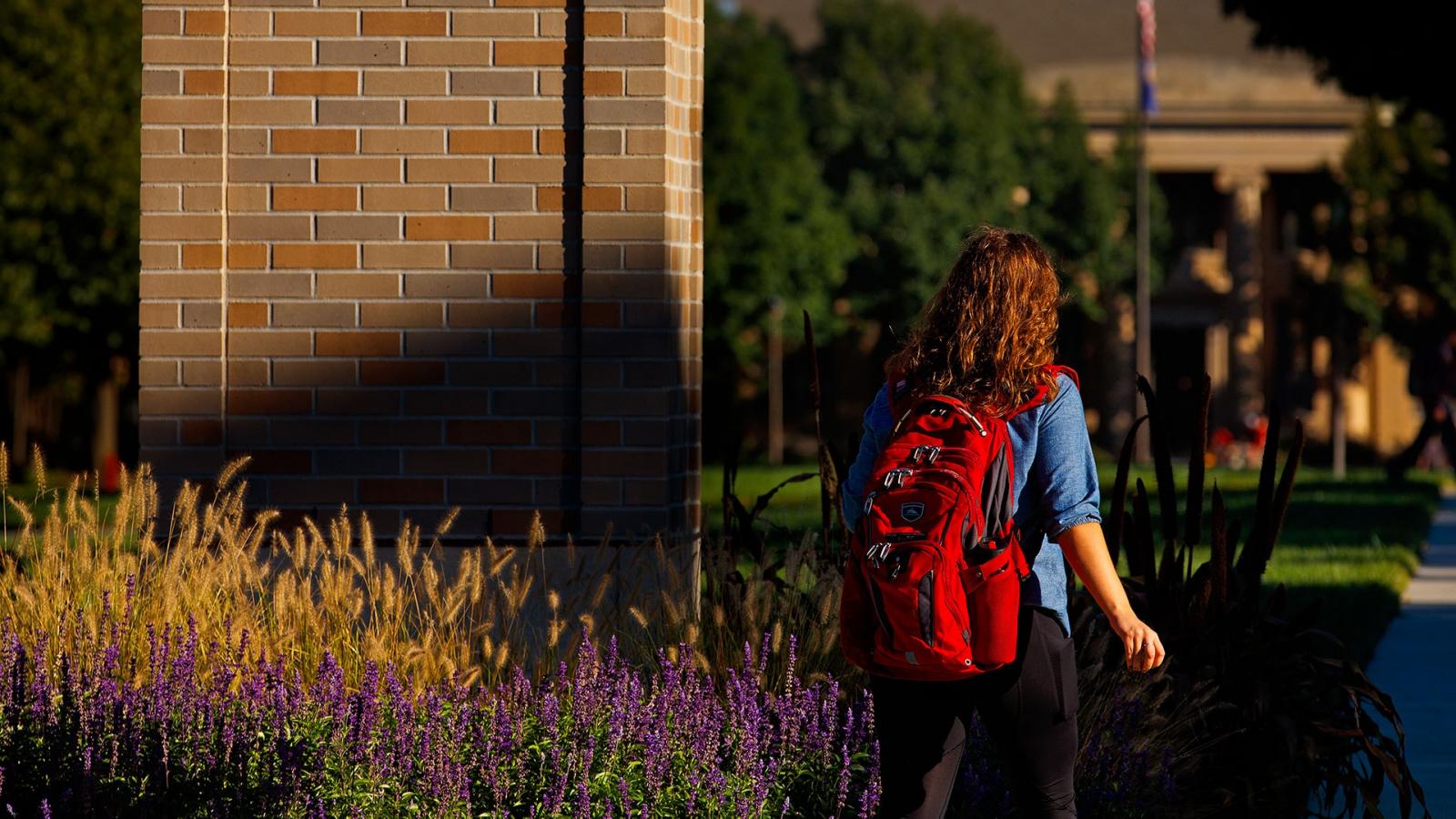University of Nebraska–Lincoln student with scarlet backpack ascends on campus.