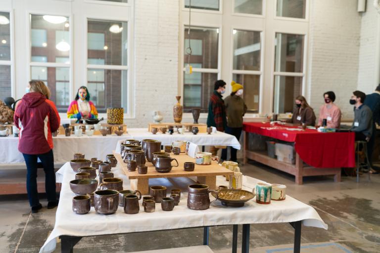 People browse work available for sale at last year’s Clay Club sale. This year’s sales, featuring work made by graduate and undergraduate students in ceramics, photography, printmaking and painting, are Dec. 9-10 in Richards Hall. Photo by Eddy Aldana.