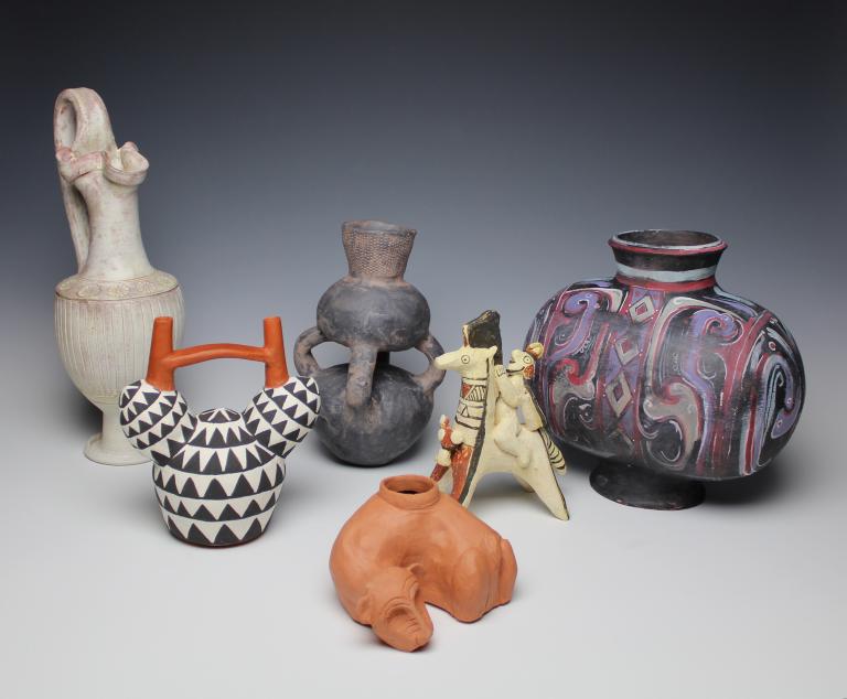 A grouping of objects from the exhibition, left to right:  Casey Beck, Etruscan Oinochoe; Sarah Rady, Nazca Achira Root Stirrup Vessel; Marina Kushner, Mangbetu Double Vessel; Sarah Rady, Thin Orangeware Dog Effigy Vessel from Teotihuacan, Mexico; Christopher Williams, Cypriot Terra Cotta Horse and Rider; and Charlotte Middleton, Han Dynasty Cocoon Vessel.